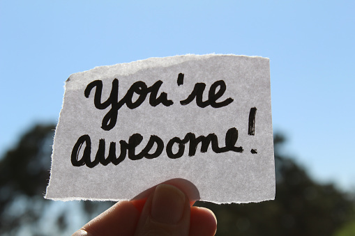 You are awesome words hand written on a note