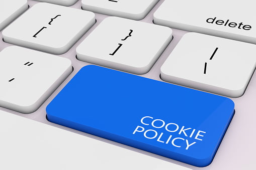 blue cookie policy key on a white laptop keyboard